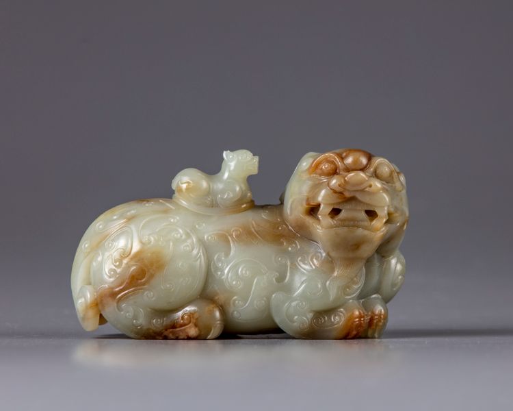 A CHINESE CELADON AND RUSSET JADE BUDDHIST LION WATER DROPPER, CHINA, QING DYNASTY (1644-1911)