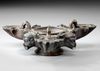 A ROMAN BRONZE THREE-NOZZLED OIL LAMP WITH THEATRE MASK AND ROSETTES AS DECORATION, CIRCA 1ST-2ND CENTURY A.D.