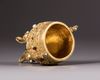 A Chinese gilt bronze inlaid tripod cup