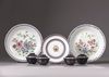 Three Chinese plates and four sets of blue-ground famille rose cups and saucers