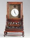 A Chinese gilt bronze table clock in a hongmu case and stand
