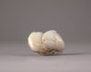 A Chinese celadon and russet jade carving of two peaches