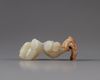 A pale jade carving of two boys with a wooden stand