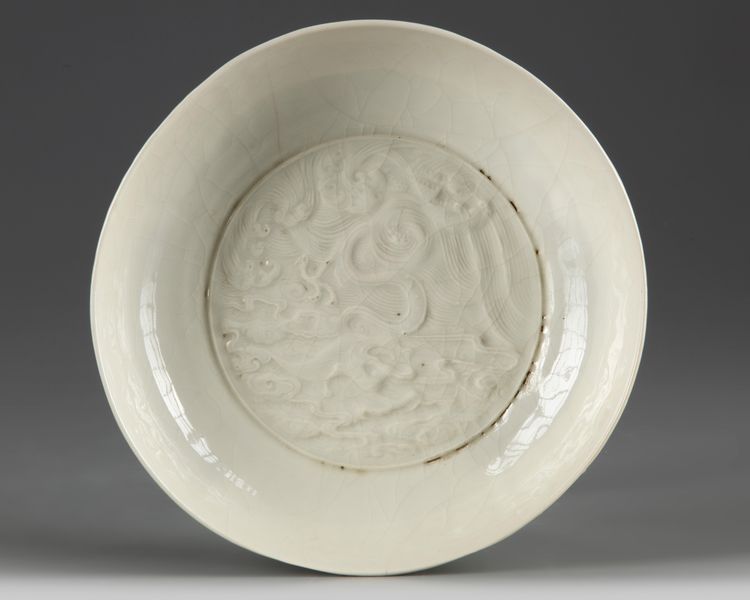 A Chinese white-glazed moulded ‘dragon’ dish