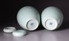 A PAIR OF CHINESE CELADON-GLAZED JARS AND COVERS