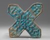 An Islamic turquoise cross shaped tile