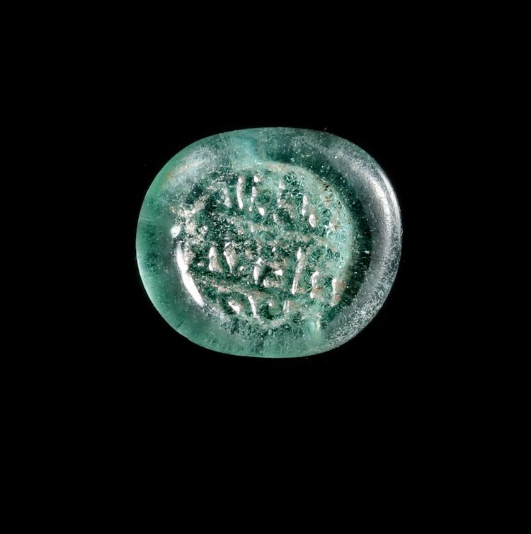 A FATIMID GLASS WEIGHT OF HALF DIRHAM, EGYPT AL-HAKIM BI-AMR ALLAH (386AH-411AH/ 996AD-1021AD)