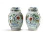 A pair of Chinese wucai 'floral' ovoid vases and covers