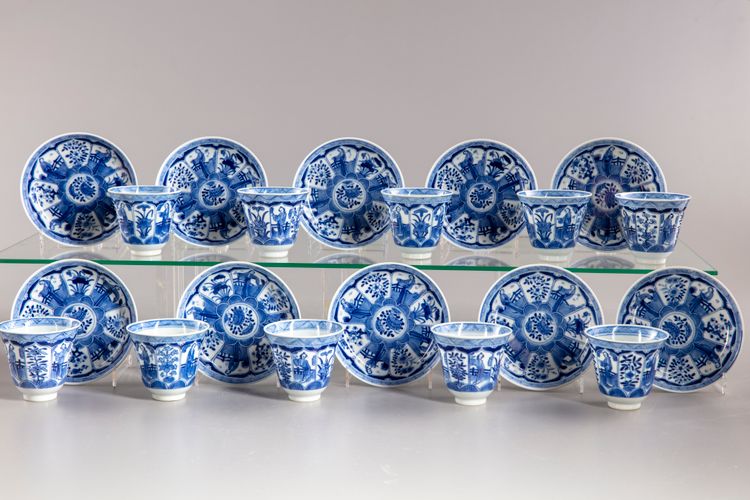 A group of eleven blue and white saucers and ten cups