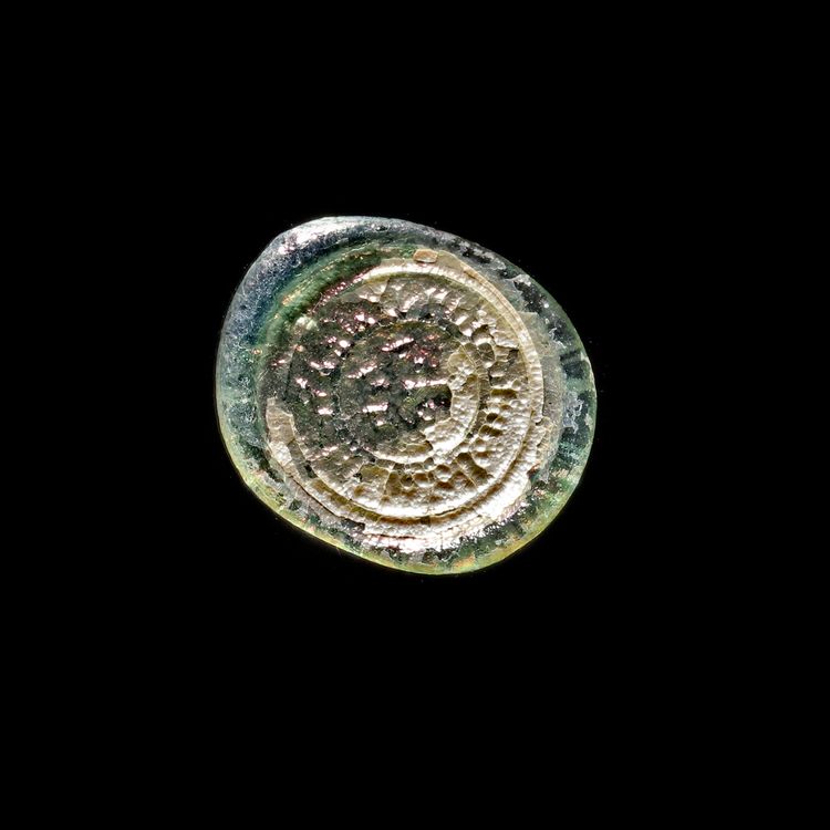 A FATIMID GLASS WEIGHT OF HALF DIRHAM, EGYPT AL-MUSTANSIR BI-ALLAH (AH 427-487 / 1036-1094 AD)