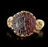 A BYZANTINE GOLD RING SET WITH A GARNET INTAGLIO, 6TH CENTURY AD OR LATER