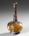 AN AMBER GLASS LOBED BOTTLE, PERSIA 9TH-11TH CENTURY