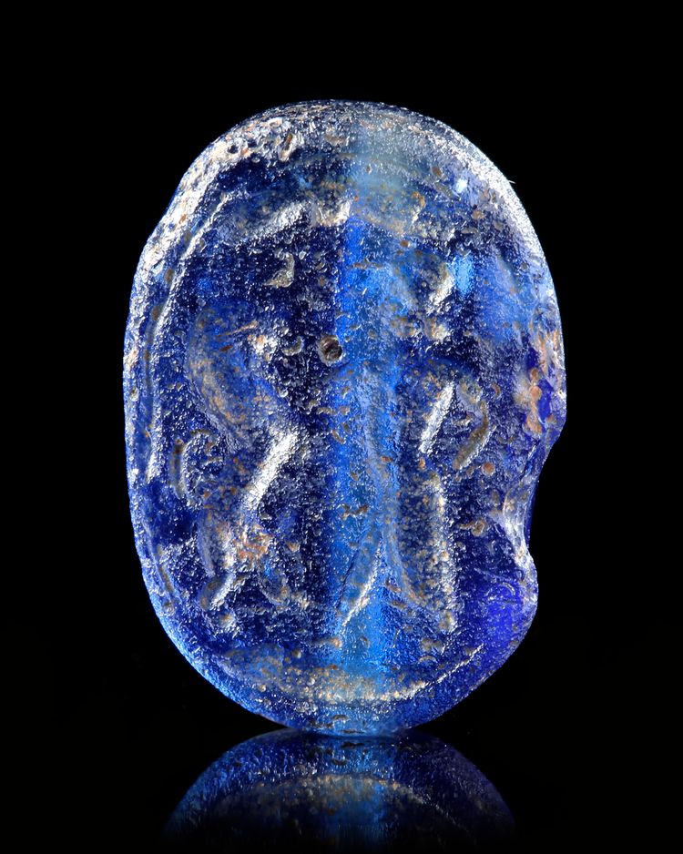 A BLUE GLASS SCARABOID SHOWING A MAN FIGHTING A LION, 6TH CENTURY BC