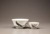 An en grisaille 'pheasant' tea cup and bowl