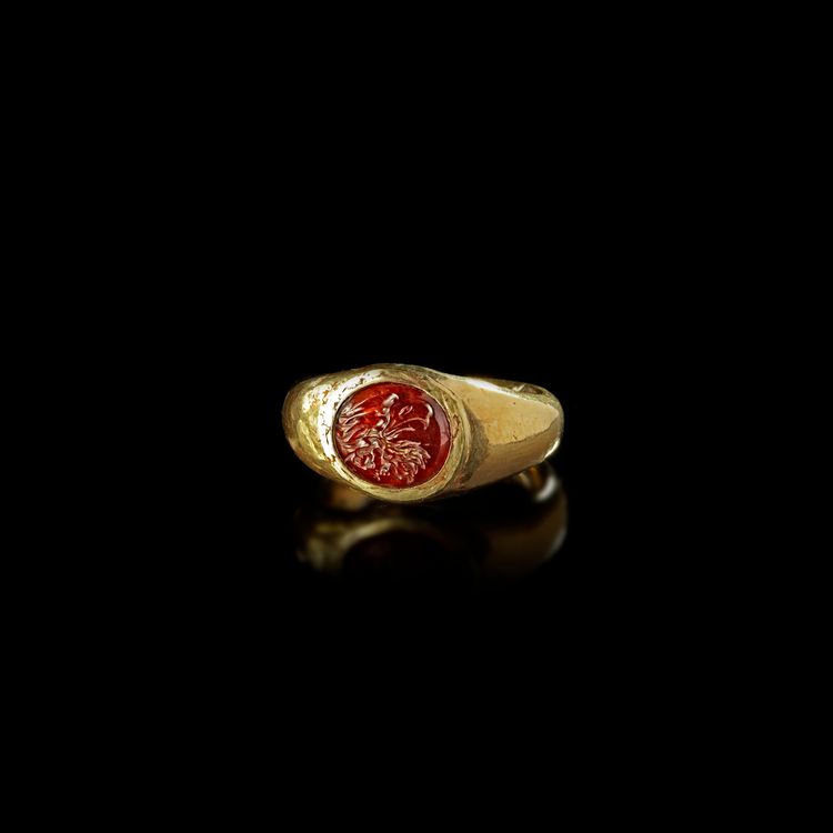 A HOLLOW ROMAN GOLD RING WITH A GARNET INTAGLIO OF AN EAGLE'S HEAD, 1ST CENTURY AD