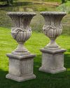 A PAIR OF CONTINENTAL SCULPTED VASES WITH RAMSHEAD