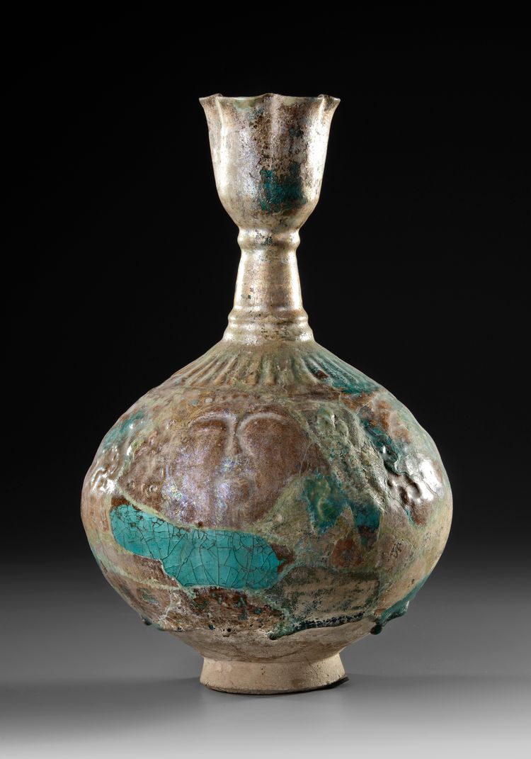 A KASHAN TURQUOISE GLAZED MOULDED BOTTLE VASE, PERSIA, 12TH CENTURY