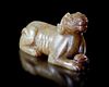 A CHINESE JADE OF A RECLINING DOG, HAN DYNASTY (206 BC–220 AD)