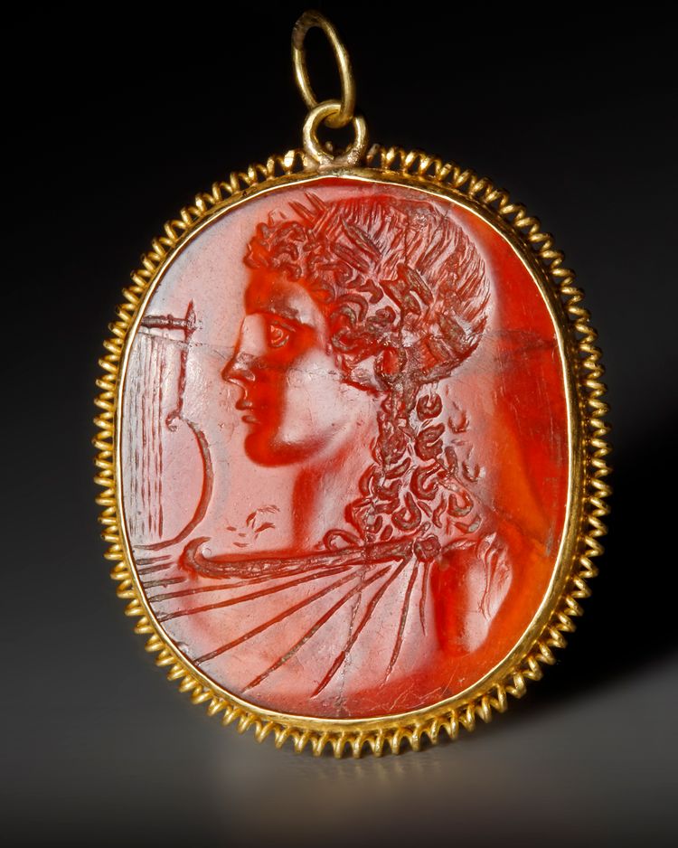 A ROMAN CARNELIAN INTAGLIO WITH THE BUST OF APOLLO, CIRCA 1ST CENTURY B.C. / A.D.