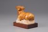 An earthenware figure of a ram on a wooden base