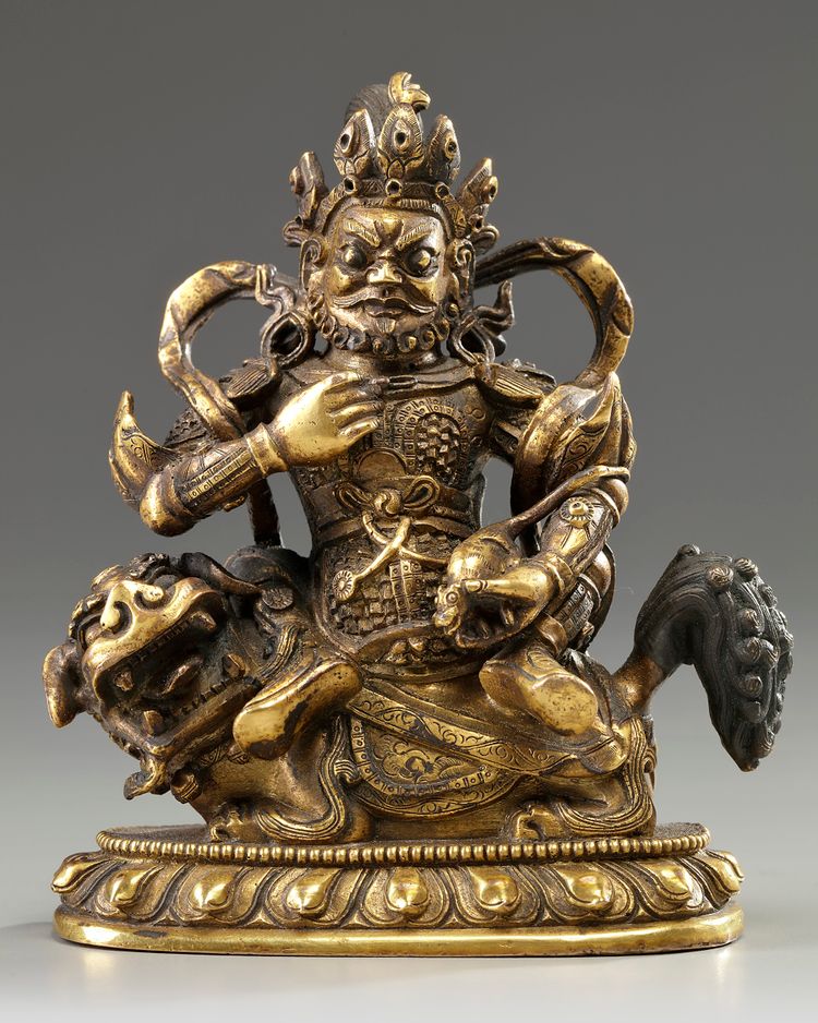 A Sino-Tibetan gilt bronze figure of Jambhala