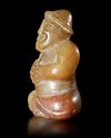 A BEIGE BROWN JADE CROSS LEGGED MALE FIGURE, CHINA, EASTER HAN DYNASTY (25 AD-220 AD)