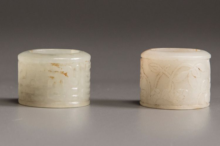 A Chinese white jade archers ring and a very pale celadon jade archers ring