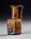 AN AMBER MOLDED GLASS JUGLET, EASTERN MEDITERRANEAN, 1ST–3RD CENTURY AD