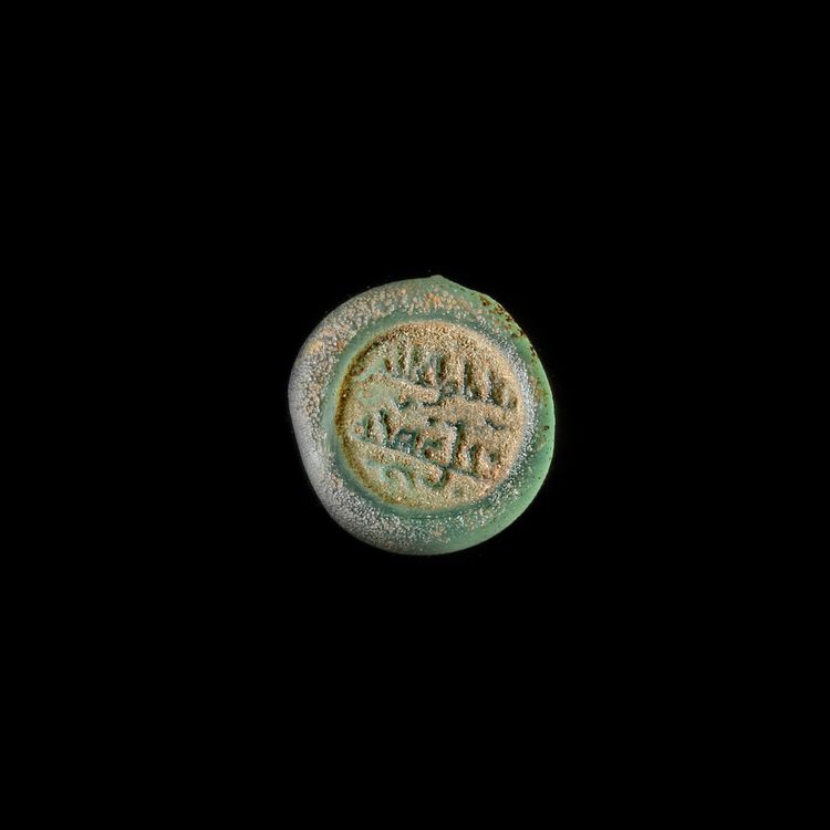 A FATIMID GLASS WEIGHT OF HALF DIRHAM, AL-HAKIM BI-AMR ALLAH (386AH-411AH/ 996AD-1021AD)