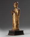 A Chinese gilt-lacquered bronze figure of a monk