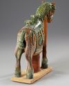 A CHINESE GREEN AND BROWN  GLAZED HORSE, MING DYNASTY (1368-1644 AD)