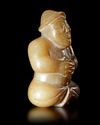 A BEIGE BROWN JADE CROSS LEGGED MALE FIGURE, CHINA, EASTER HAN DYNASTY (25 AD-220 AD)